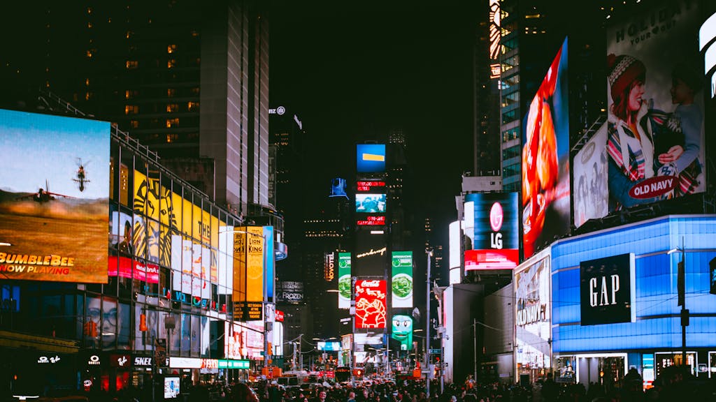 Illuminated billboards and bustling crowds at iconic Times Square, NYC, during the night.